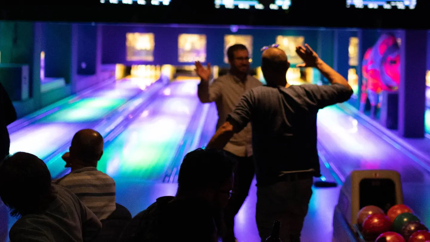 Venner som feirer et strike på bowlingbanen hos Oslo Bar & Bowling