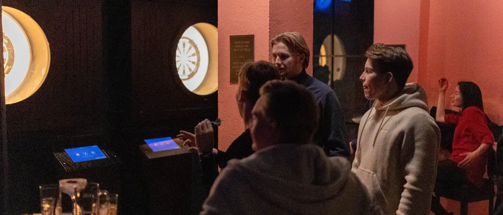 Gjeng som spiller Flyby Darts med digital poengtavle