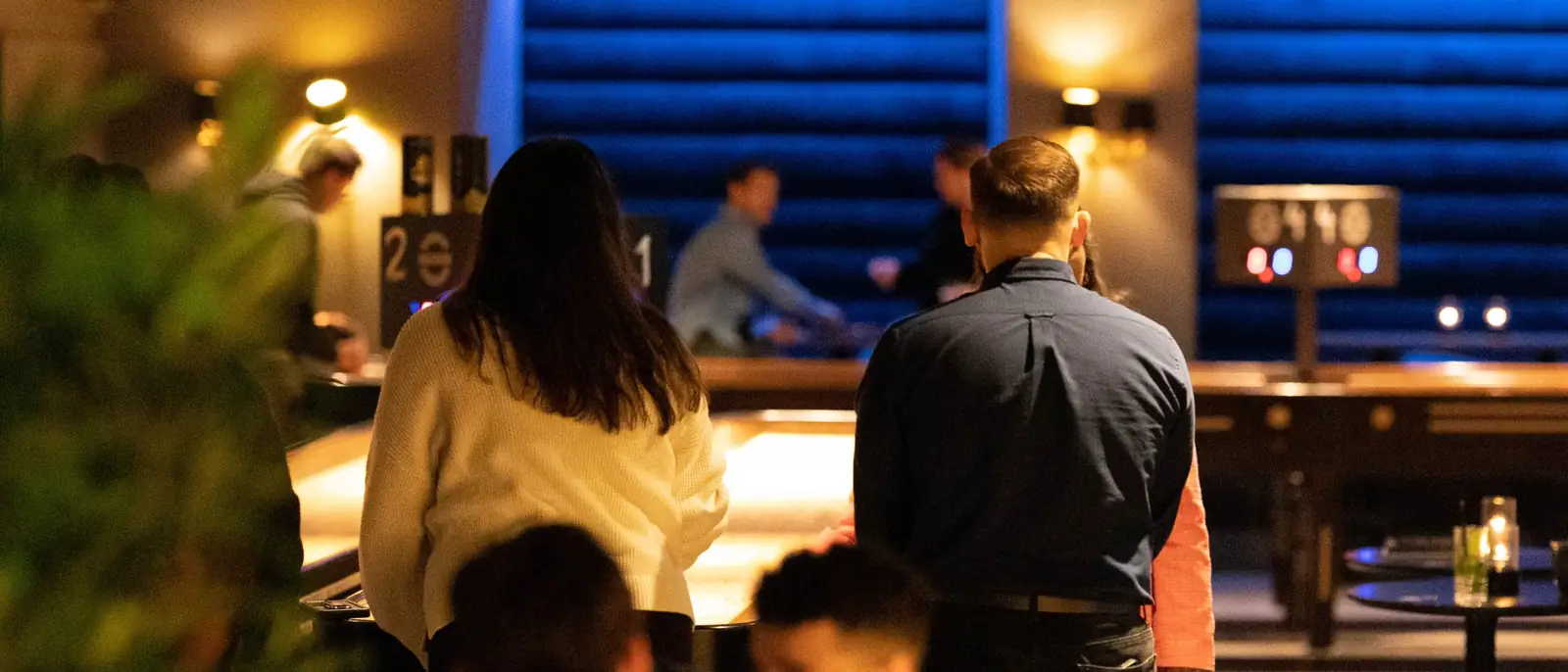 Team som spiller shuffleboard under en kickoff hos Oslo Bar & Bowling